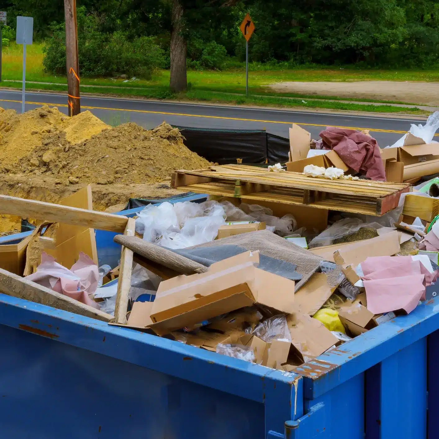 Blue dumpster full of debris